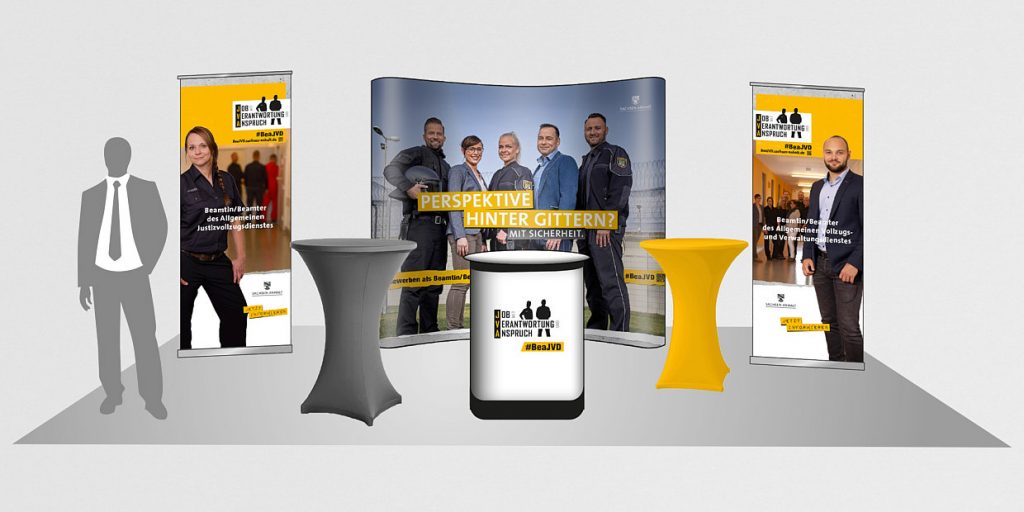 Justizvollzug Sachsen-Anhalt: Recruiting-Kampagne 8 Visualisierung eines Messestands der Justizvollzugs-Kampagne mit Roll-ups und Theke