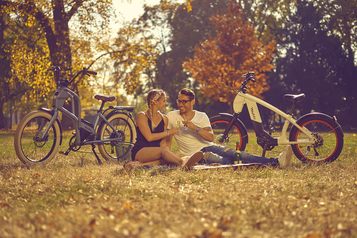 Werbefotografie für YouMo: zwei Personen im Herbstpark neben ihren E-Bikes